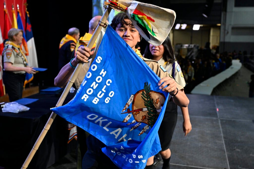 A young Pathfinder holds up a flag representing his club during the awards ceremony