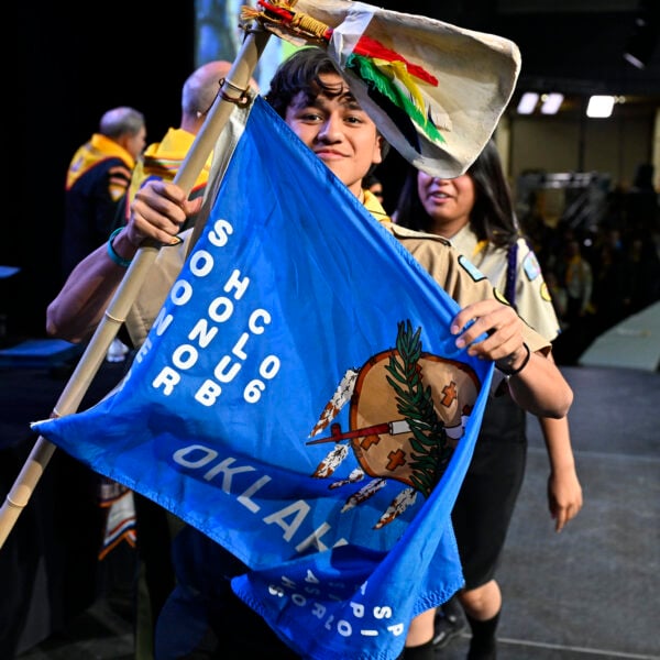 A young Pathfinder holds up a flag representing his club during the awards ceremony