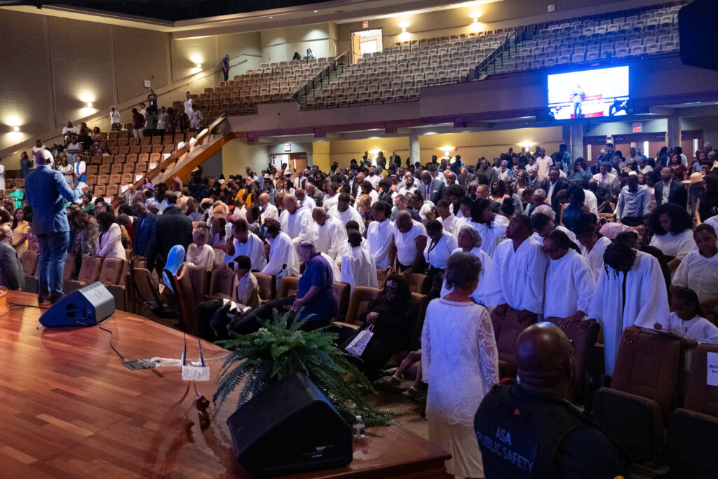 A congregation of people prepare for holy baptism.