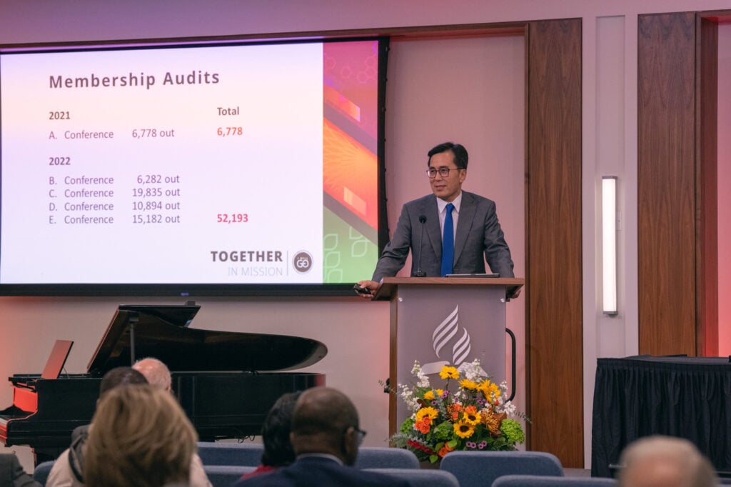 Businessman on stage with powerpoint presents at an organization meeting