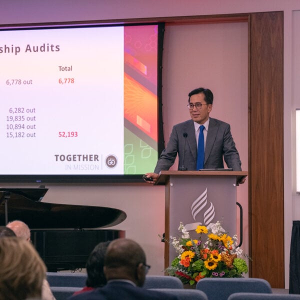 Businessman on stage with powerpoint presents at an organization meeting