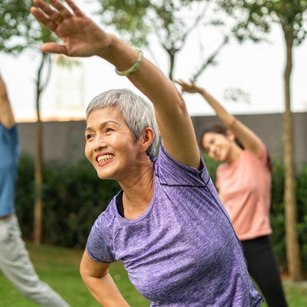 Photo of people doing aerobic exercise as a group outside.