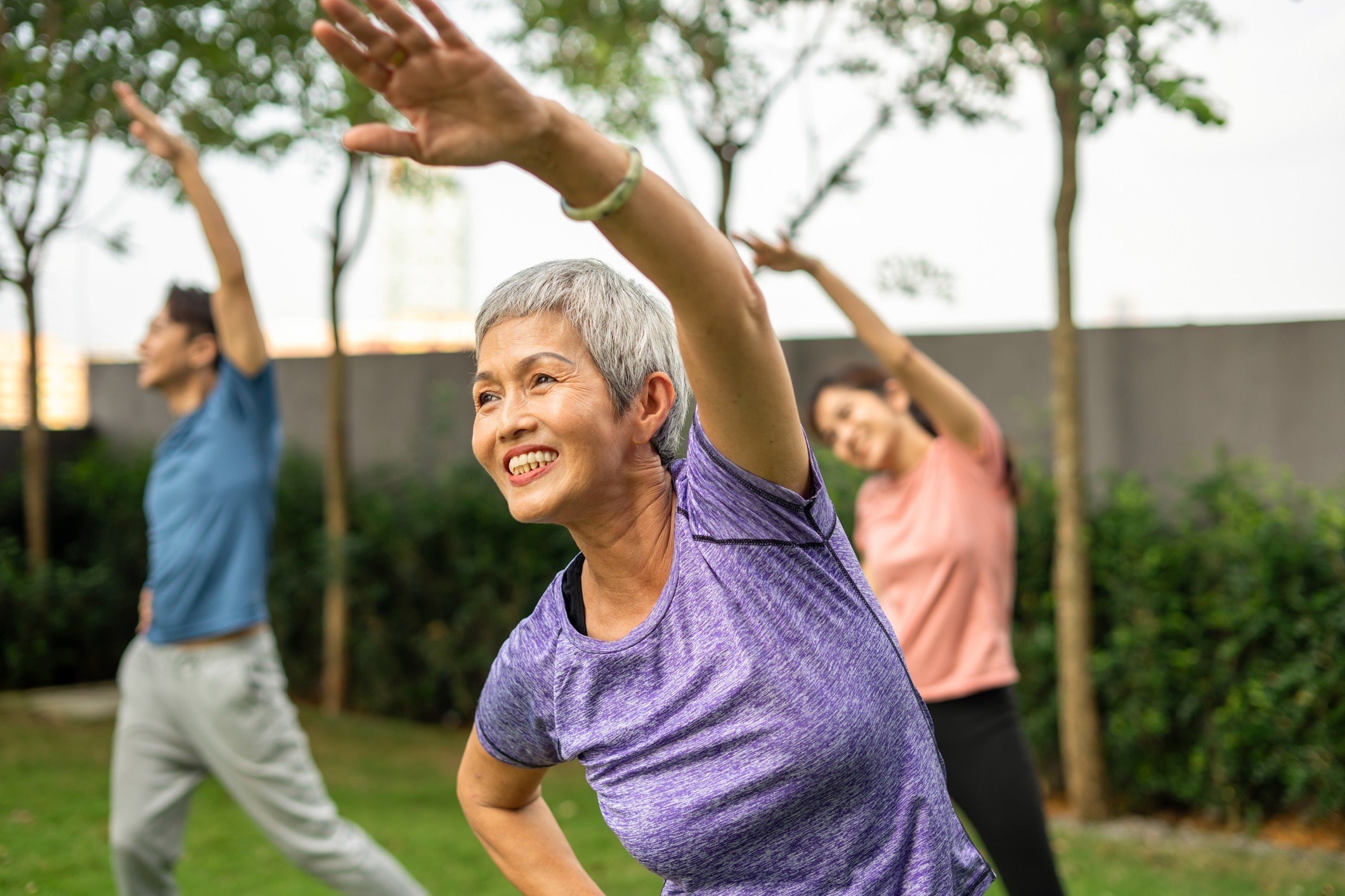 Photo of people doing aerobic exercise as a group outside.