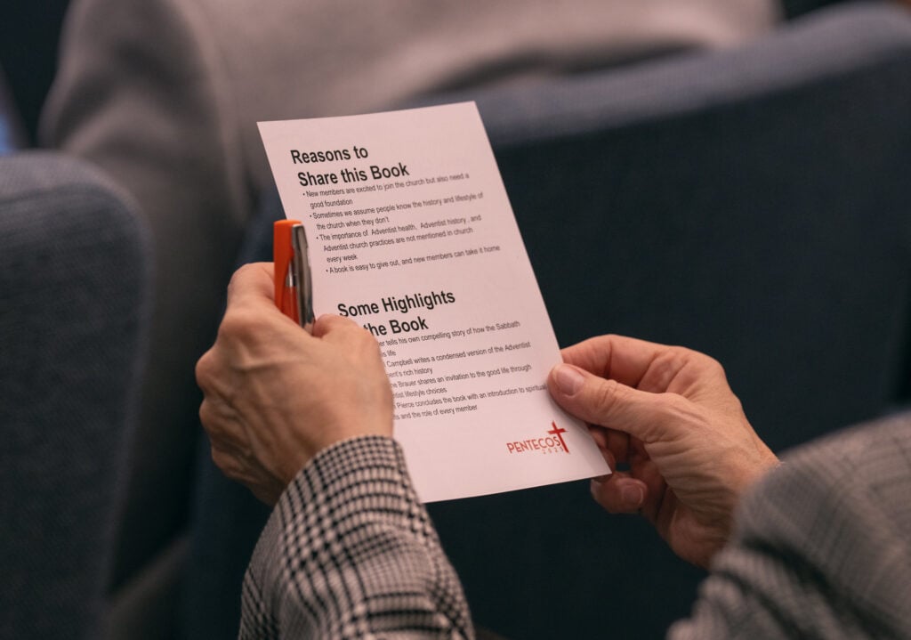 Photos showing two hands holding a white paper handout entitled 'Reasons to Share this Book.'
