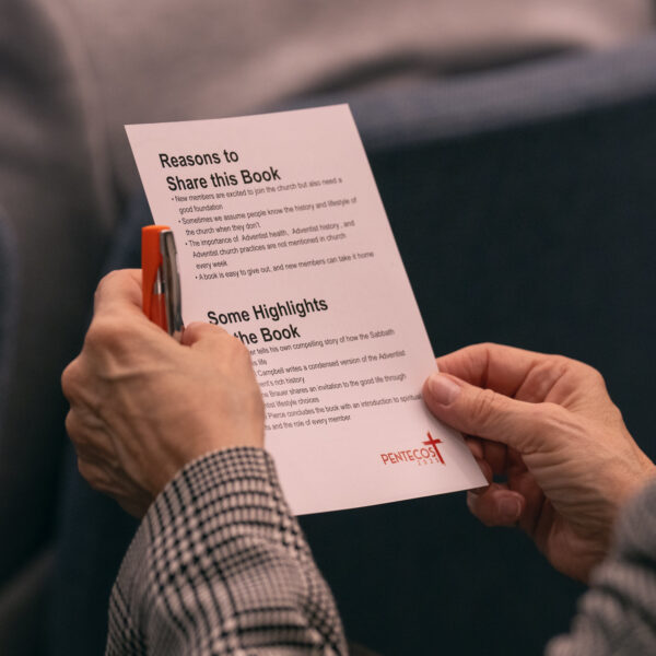 Photos showing two hands holding a white paper handout entitled 'Reasons to Share this Book.'
