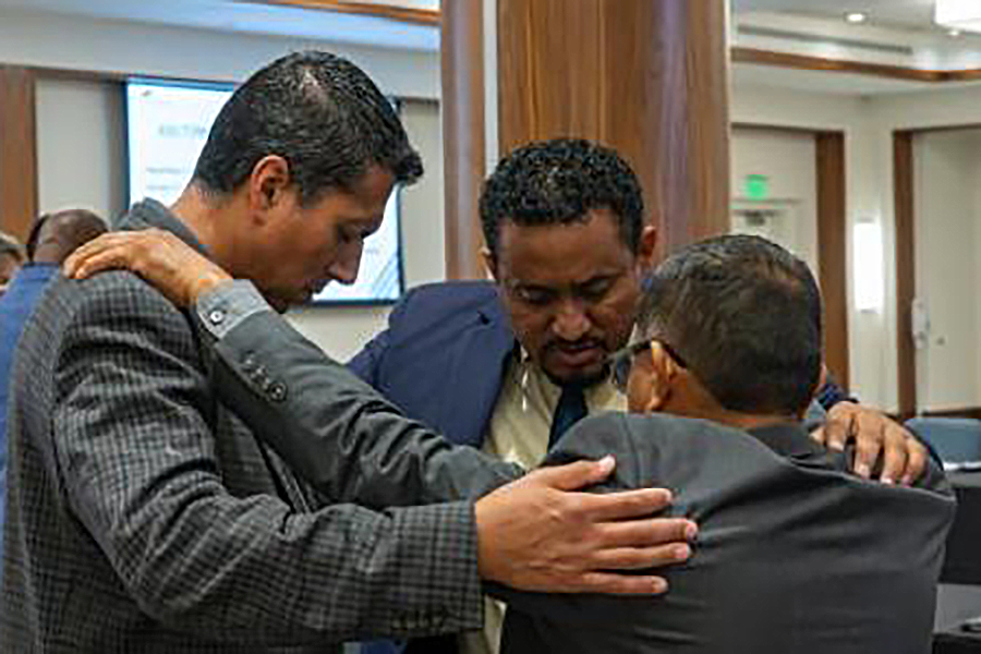Group of three men praying