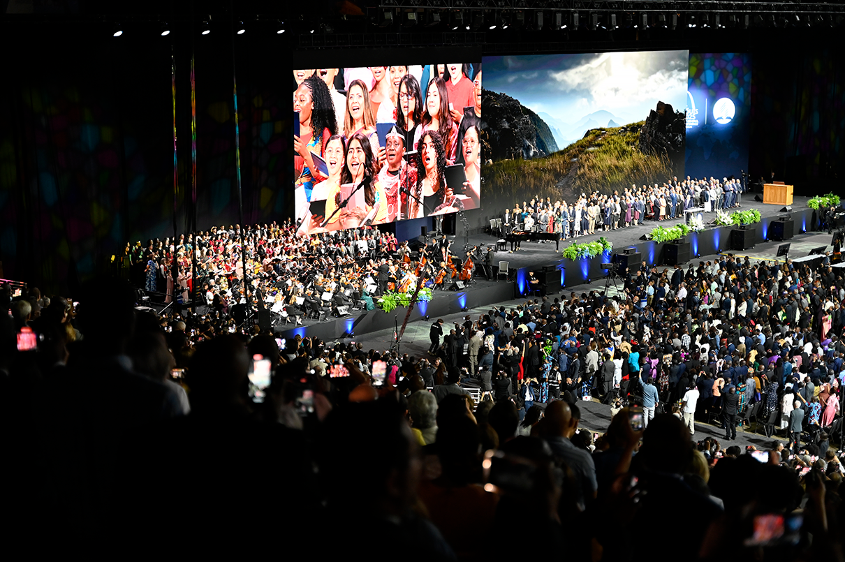 A big screen with singers and wide shot of a dome