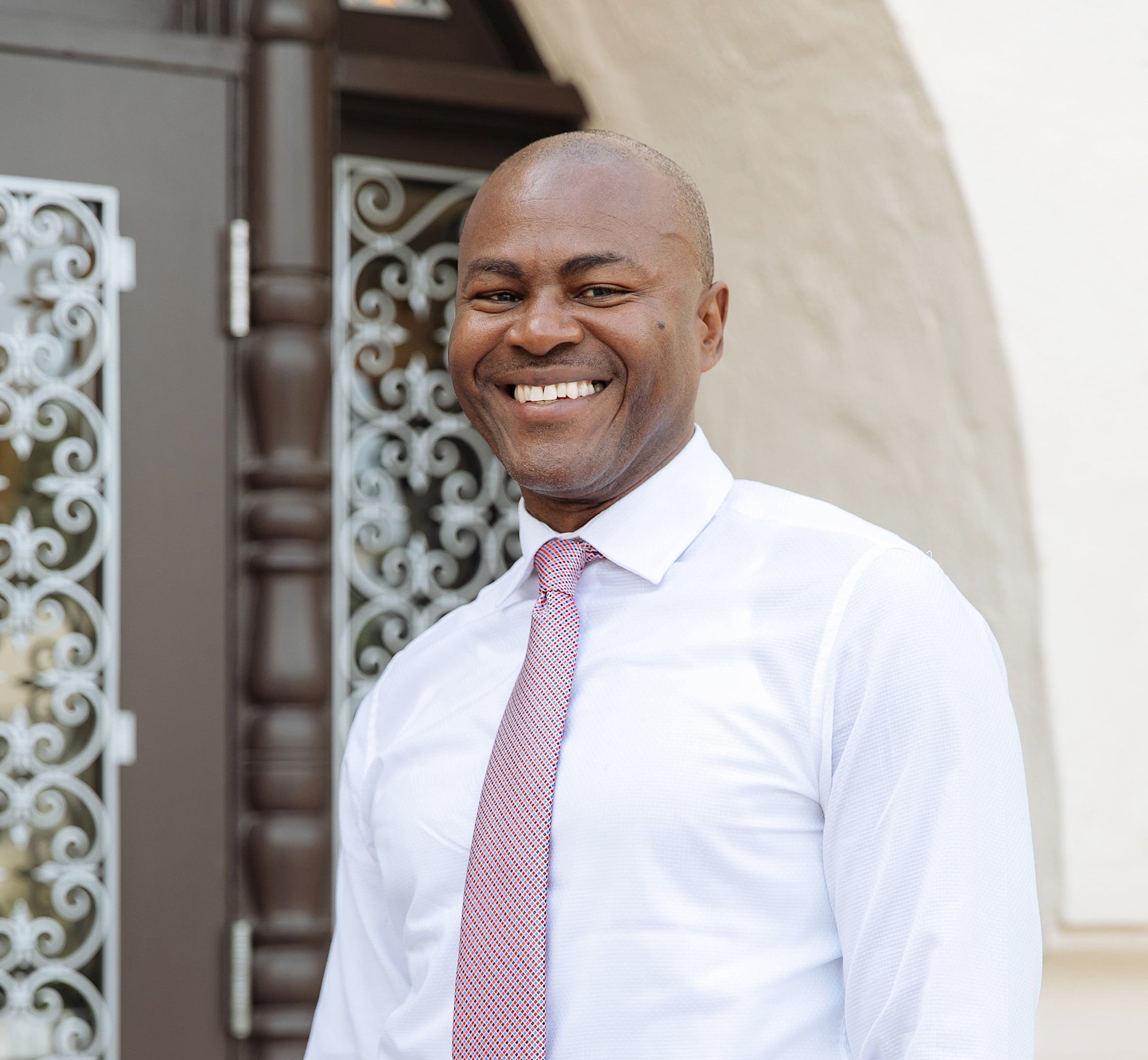 Headshot of black man in suit smiling