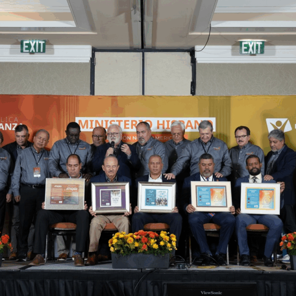 Photo of men posing with certificates on a stage.