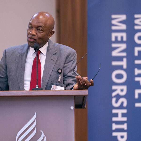 Well-dressed man speaking at a podium