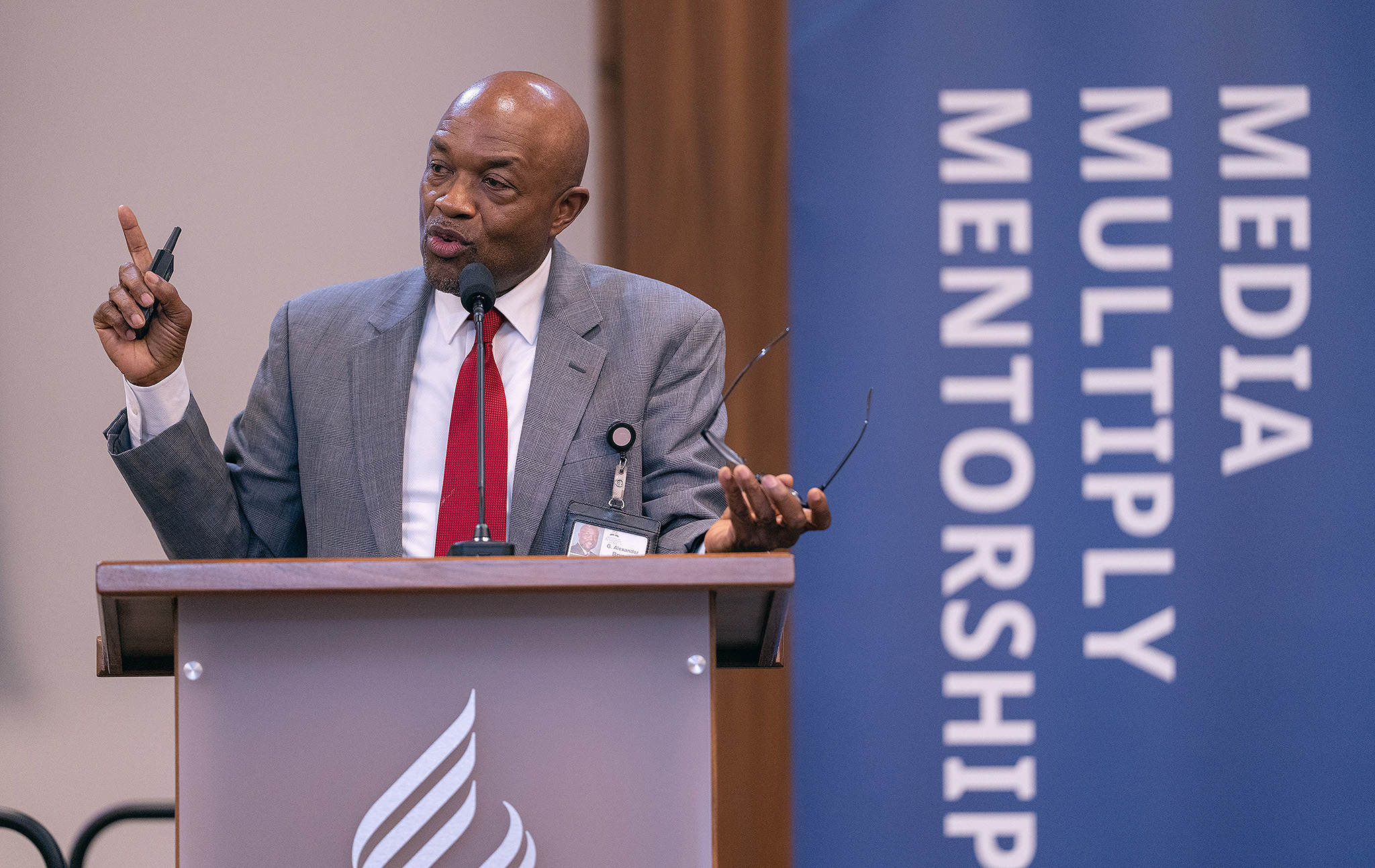 Well-dressed man speaking at a podium