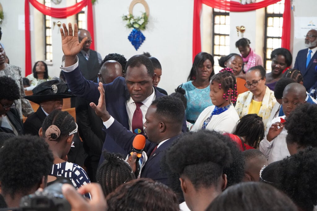 Close-up of several people standing up in a sanctuary