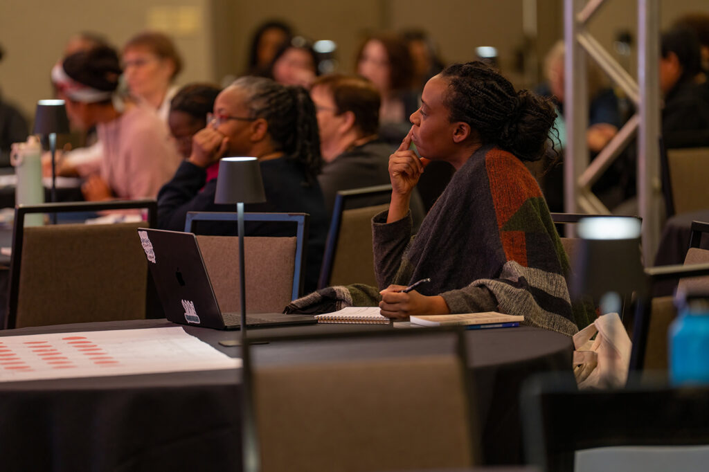 A woman listens carefully in a conference room.