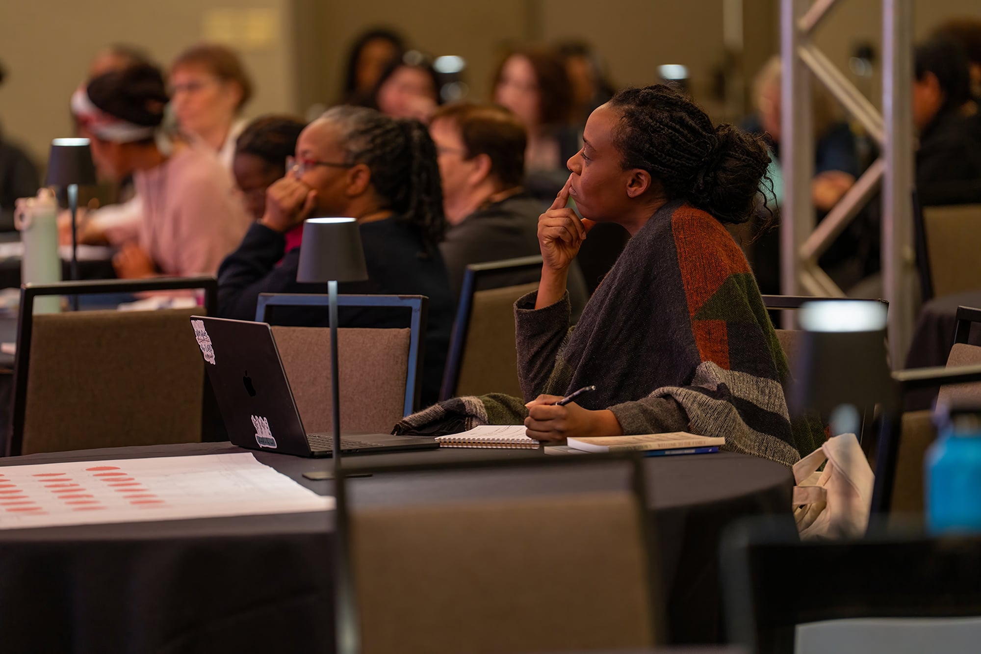 A woman listens carefully in a conference room.