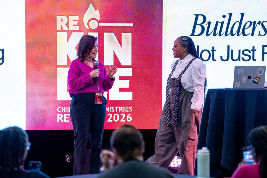 Two women on a stage with a ReKindle logo in the background.