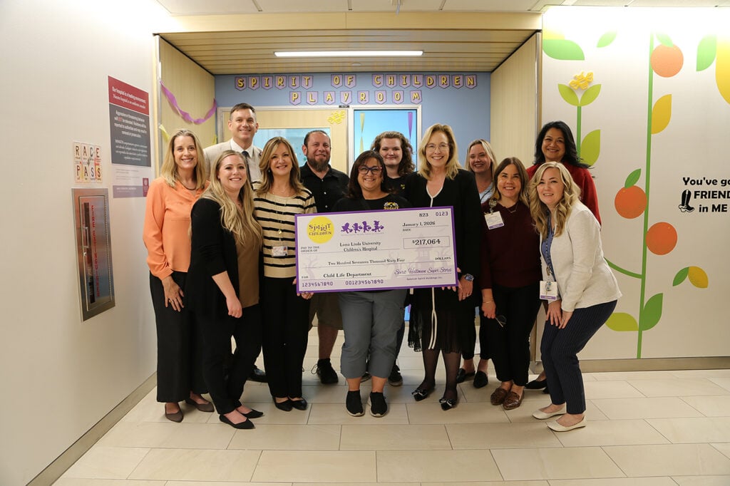 Group of people standing holding a check