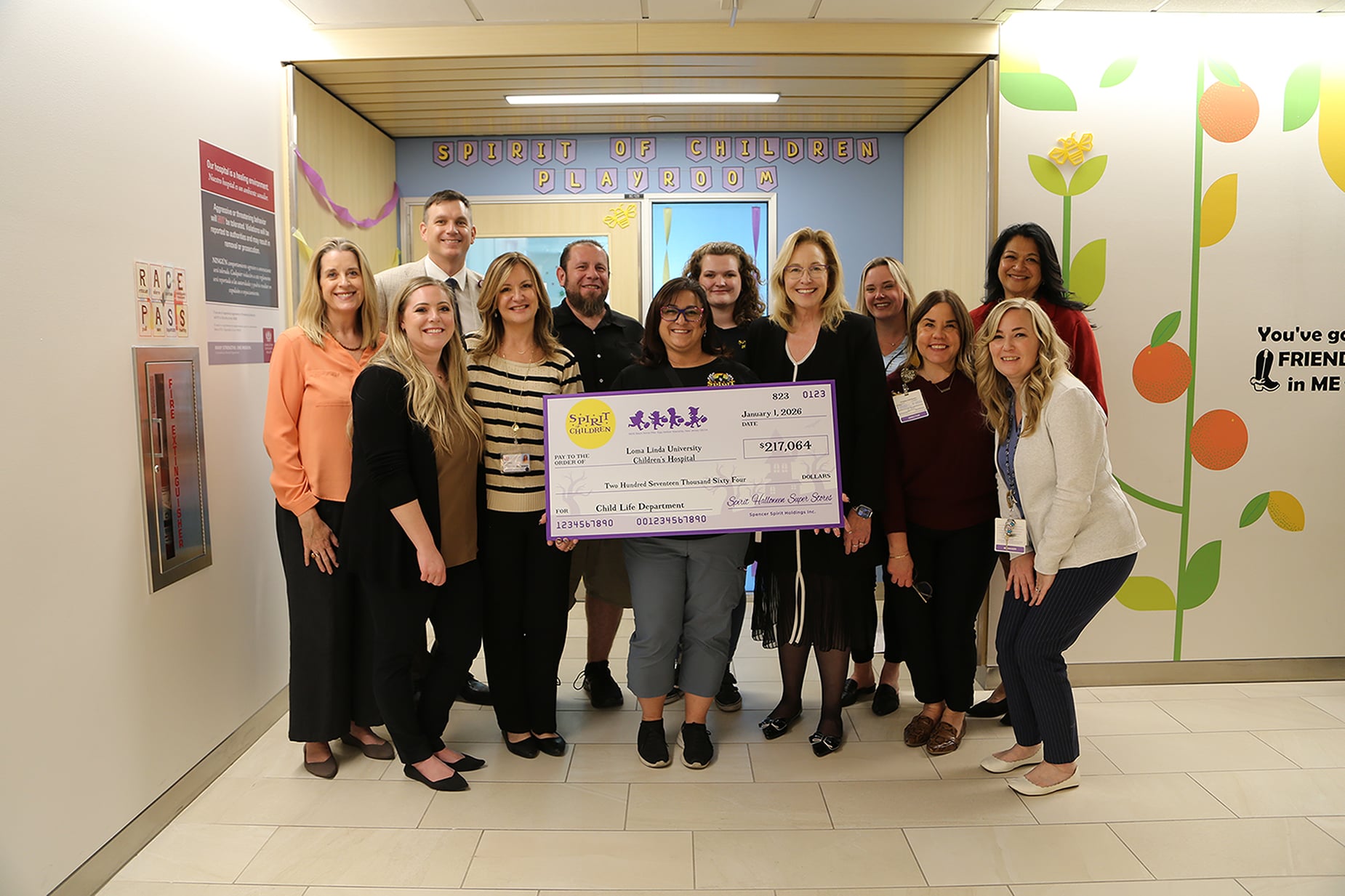Group of people standing holding a check