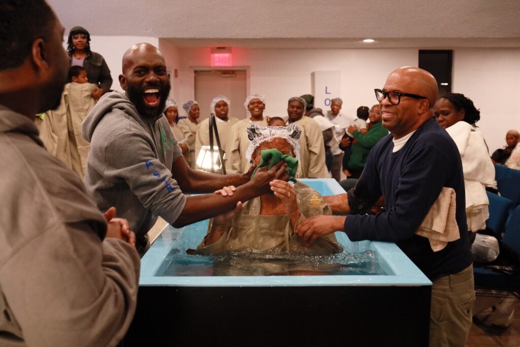 Man baptizing a lady in a baptismal pool.