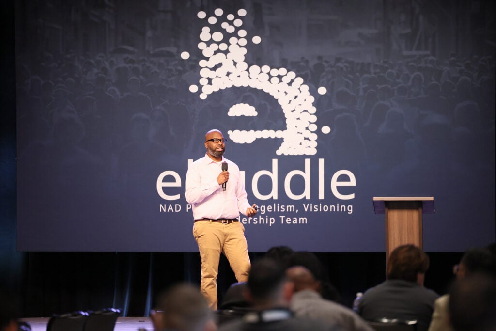 A man speaks on stage at the eHuddle conference. 