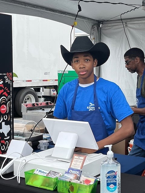 Young man standing behind a cash register.