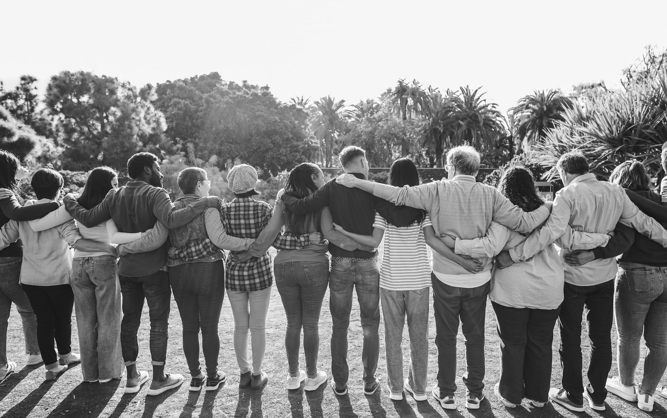 Group of multigenerational people hugging each others - Support, multiracial and diversity concept - Main focus on center people - Black and white editing