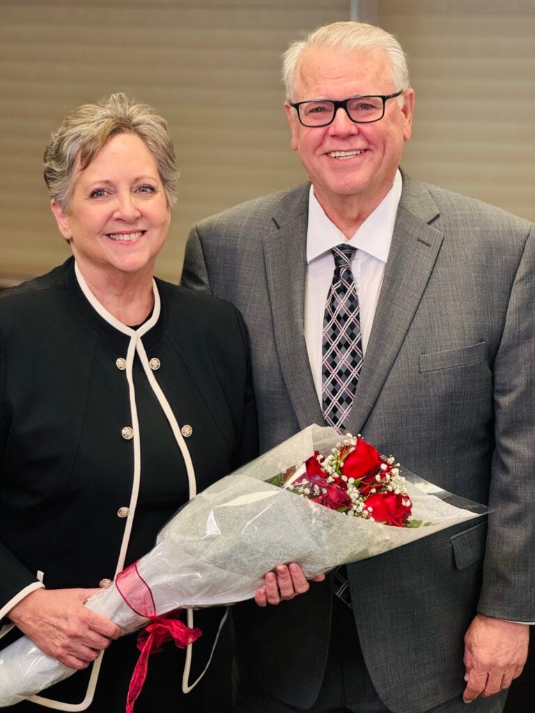 Caucasian, middle/late age male and female posing with bouquet of flowers