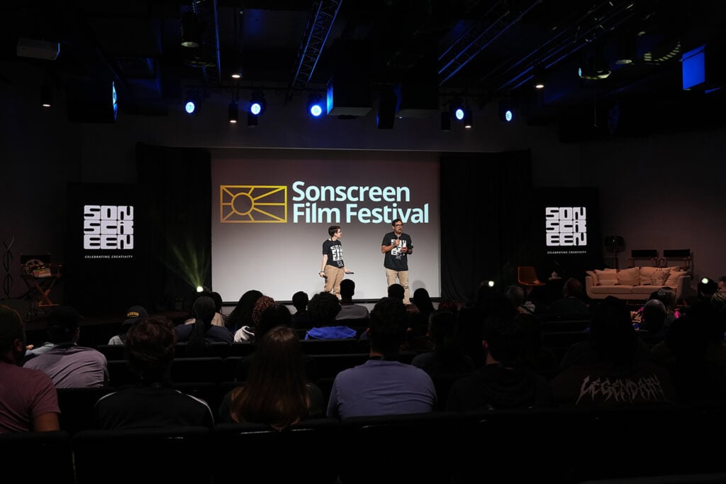 Wide shot of the Sonscreen film festival with co-directors on stage