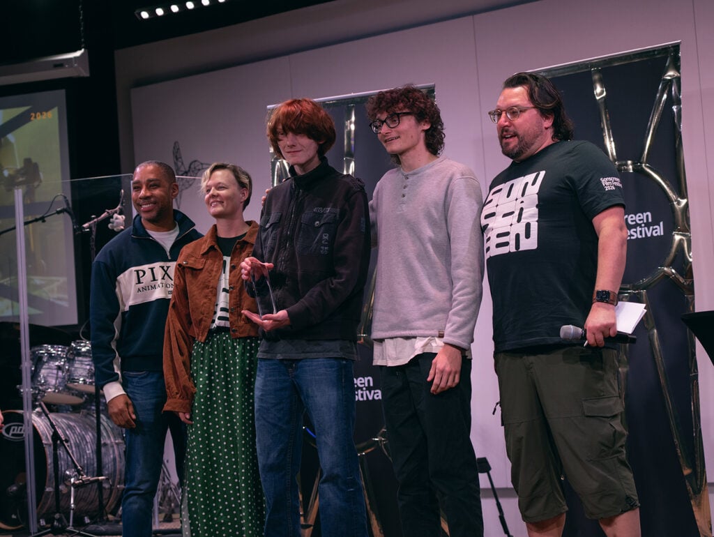 Five people pose for a photo during the Sonscreen awards ceremony. In the center is someone holding an award.