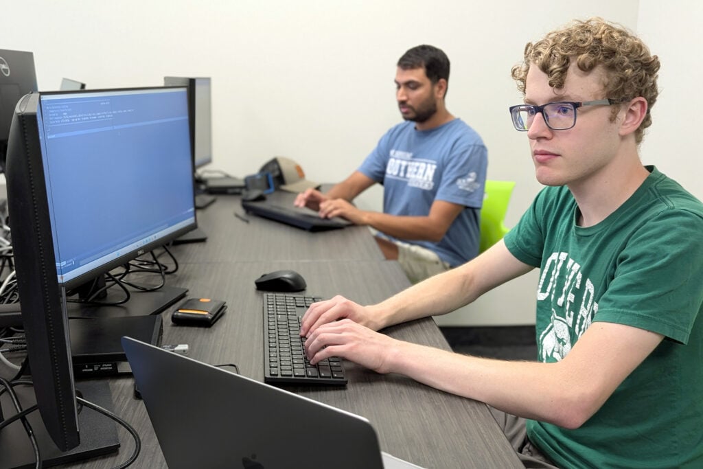 Two young adult males in a computer lab