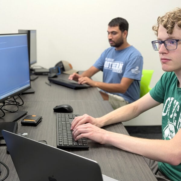 Two young adult males in a computer lab