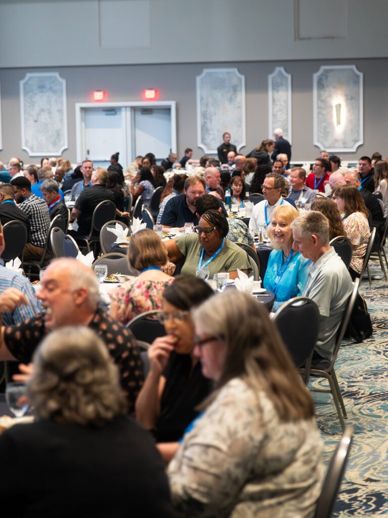 A crowd of people seated in a conference room 