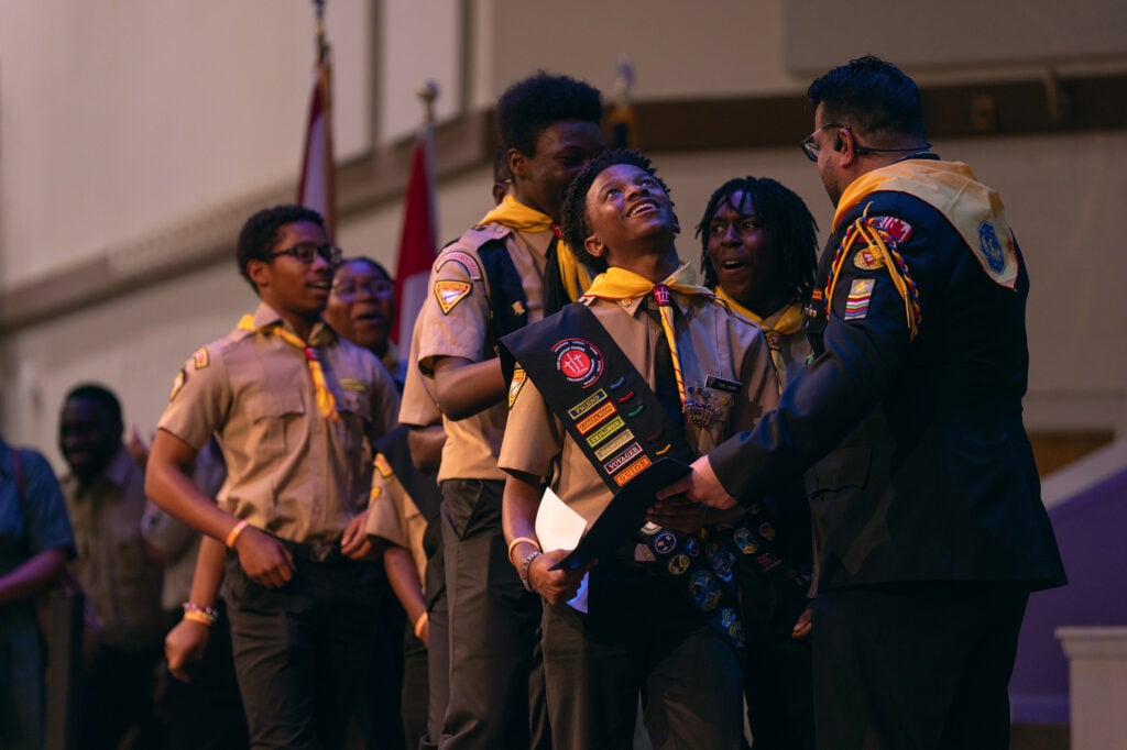A Pathfinder team collects their certificates from Pathfinder Bible Experience organizer Armando Miranda on stage.
