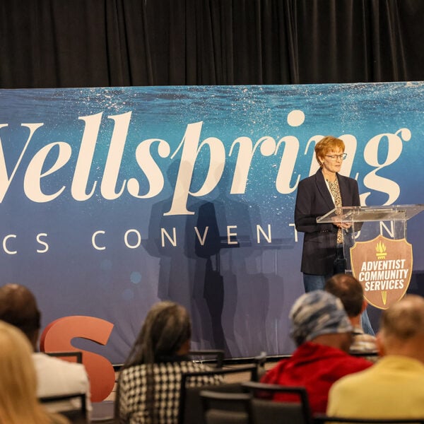 A woman stands in front of an audience at the 2026 "Wellspring" NAD ACS Convention.
