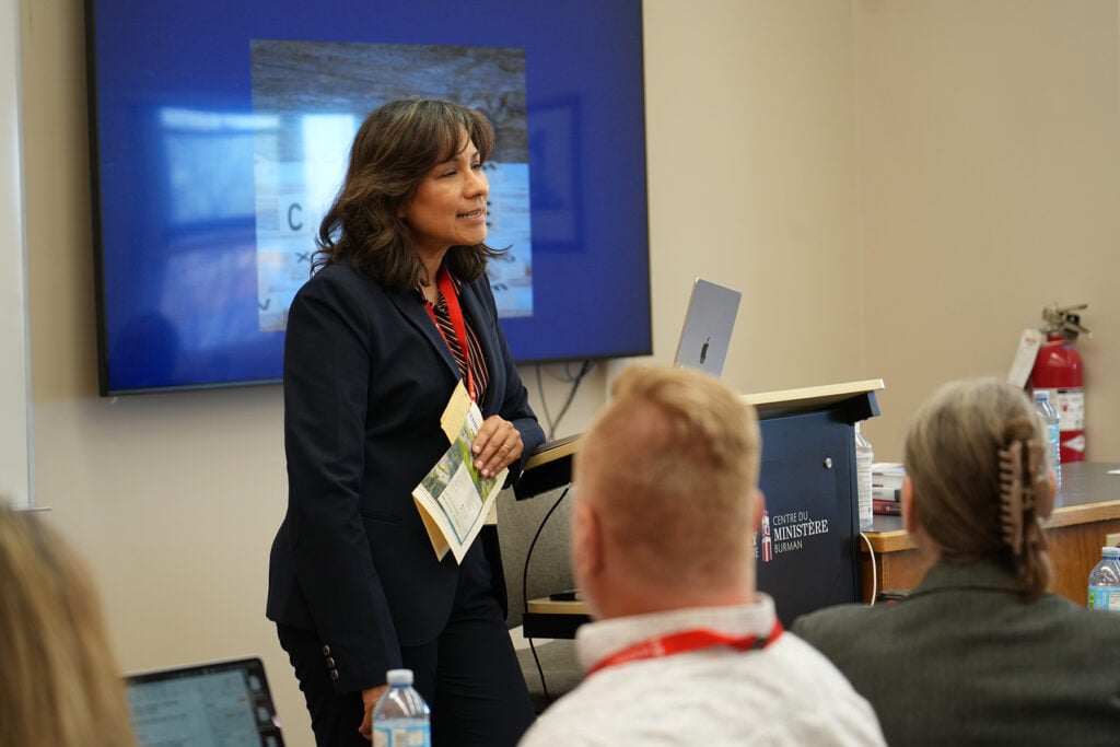 A woman stands at a podium speaking