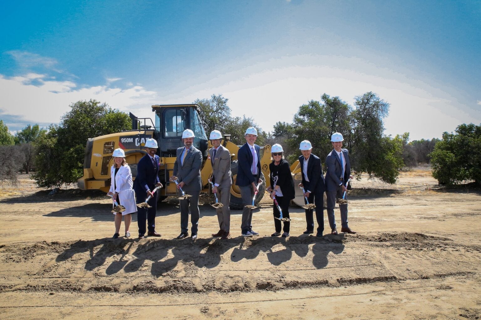 Group of people with shovels break ground on a new hospital facility in Loma Linda, California