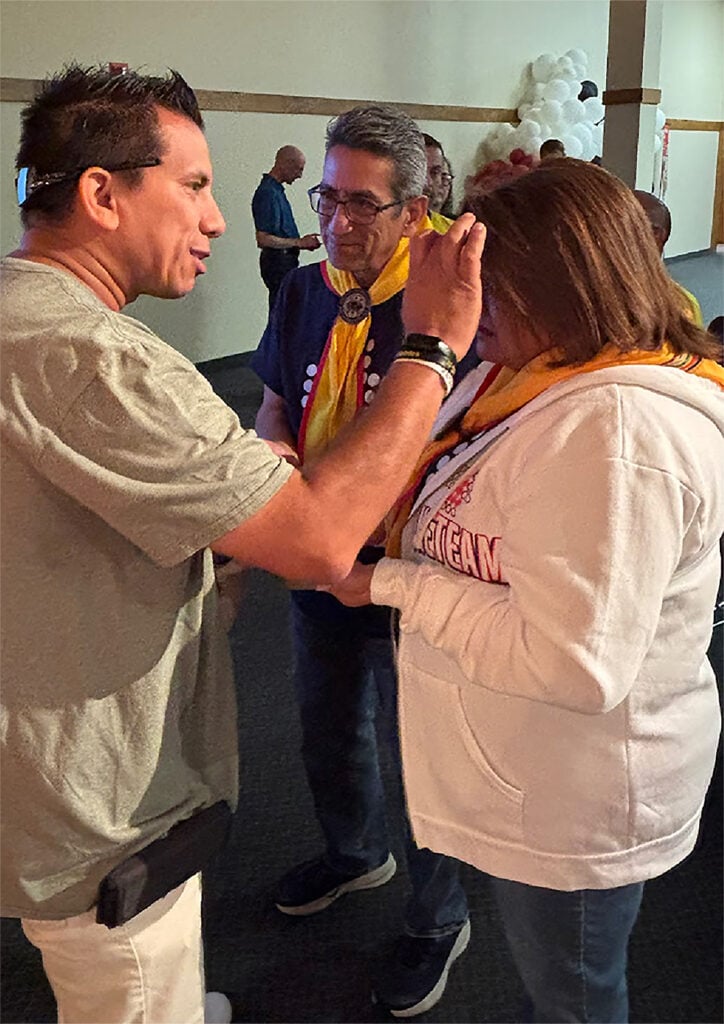 A club ministry coordinator receives oil on her forehead