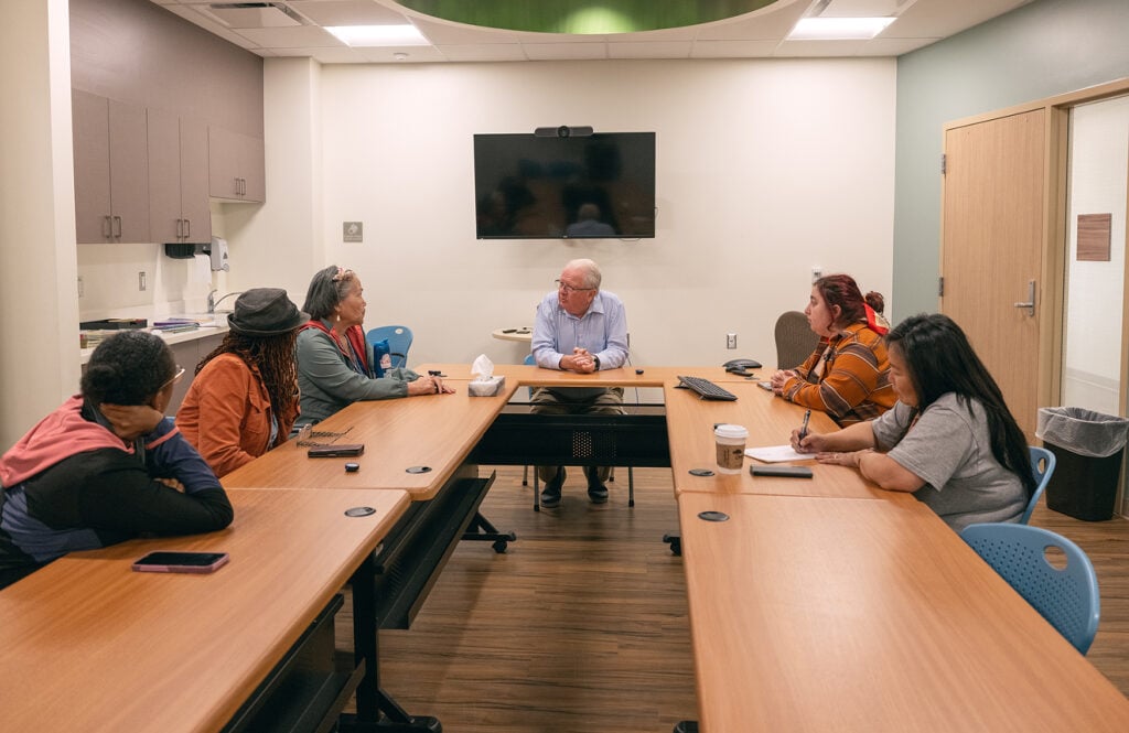 Alaska Native community representatives and church leaders sit around a conference table during a meeting in Bethel.