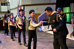 Armando Miranda Jr. and other leaders give Pathfinders their certificates at the end of PBE.