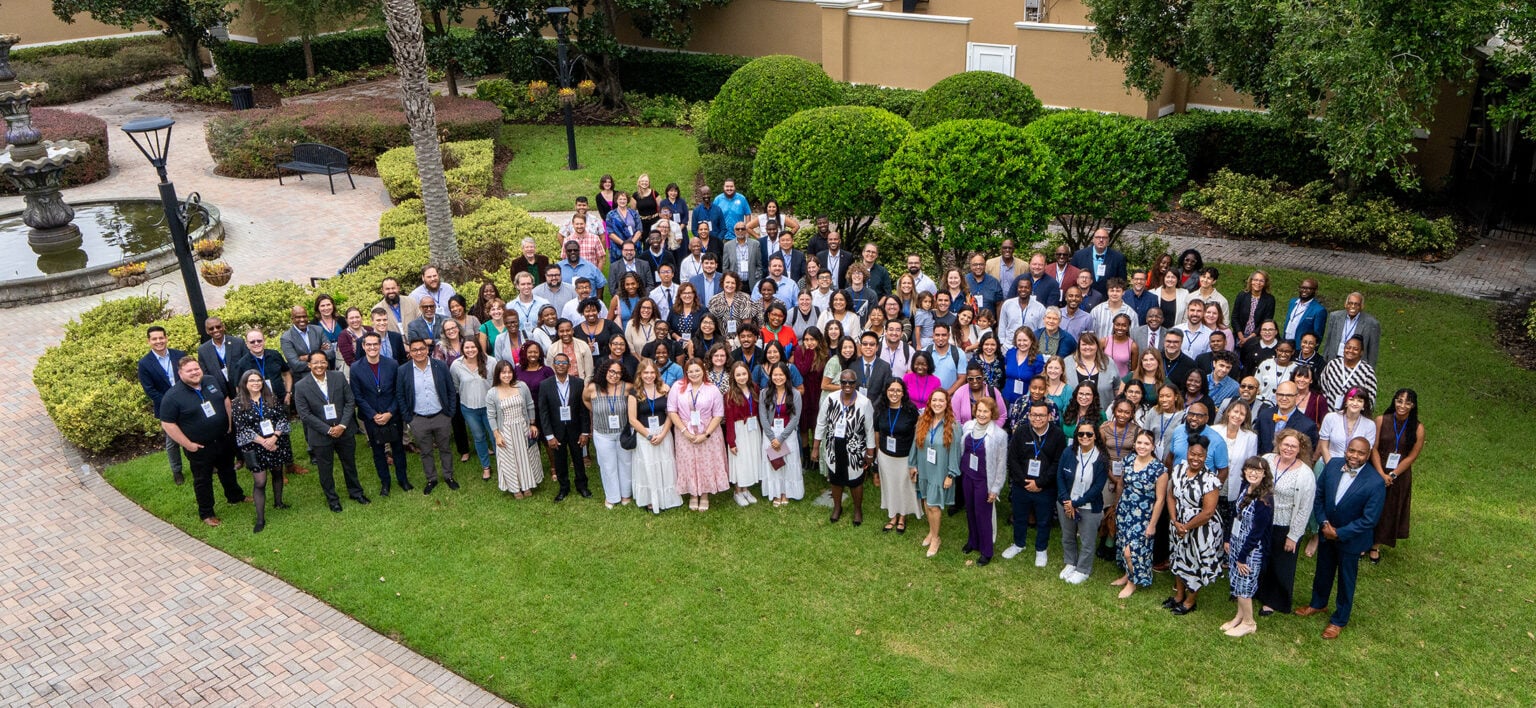 A large group poses on the grass at the SAC convention.