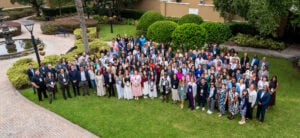 A large group poses on the grass at the SAC convention.