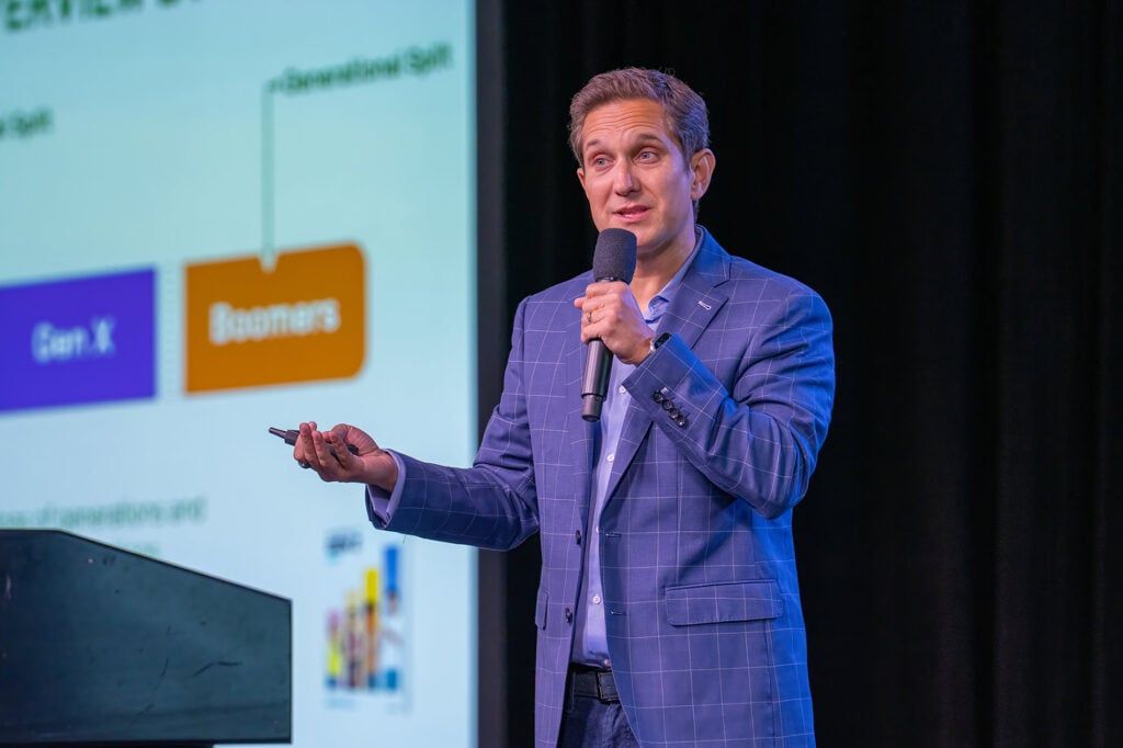Close-up of keynote speaker, Jason Dorsey, on stage at SAC. 