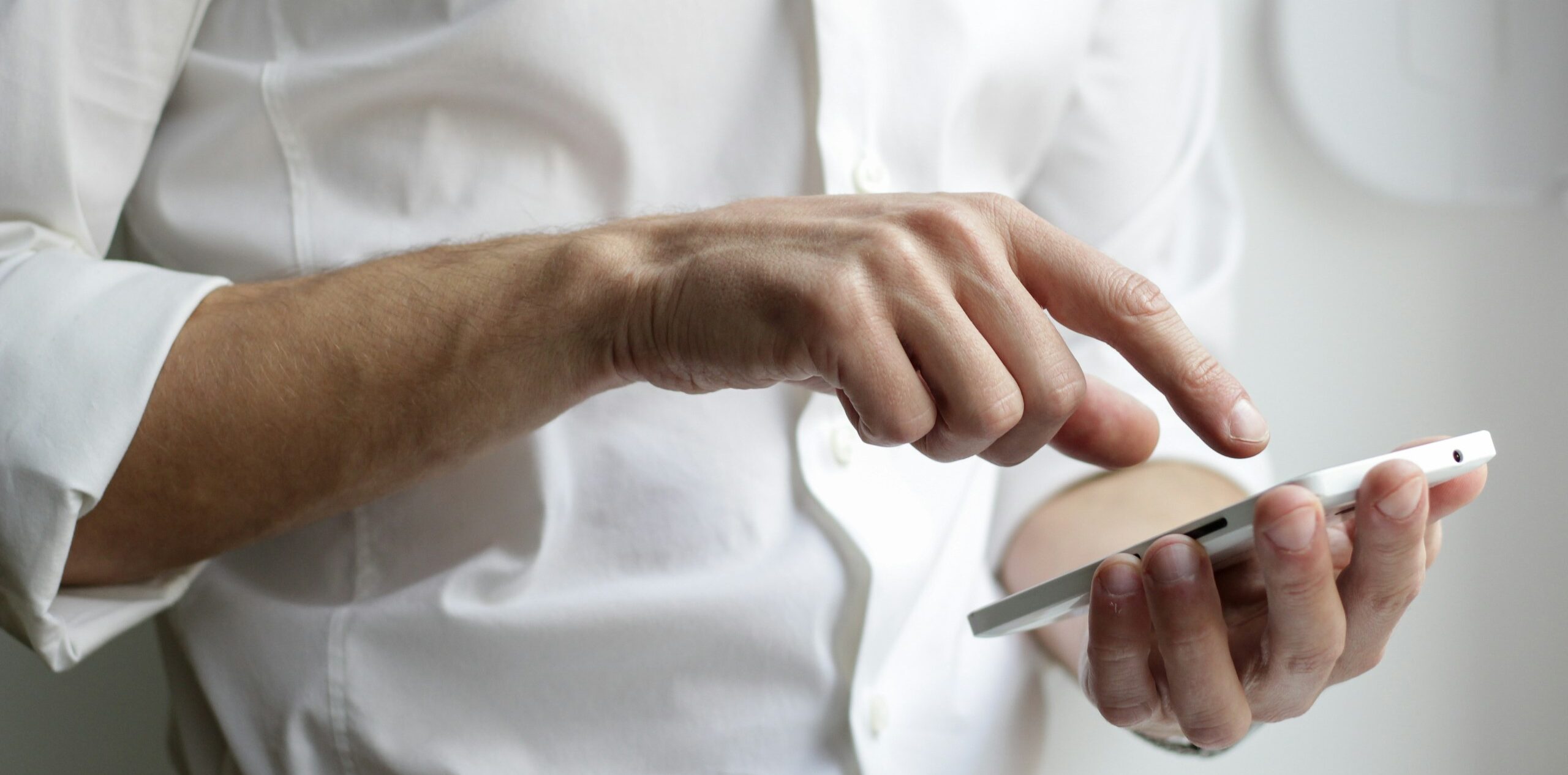 person holding white Android smartphone in white shirt