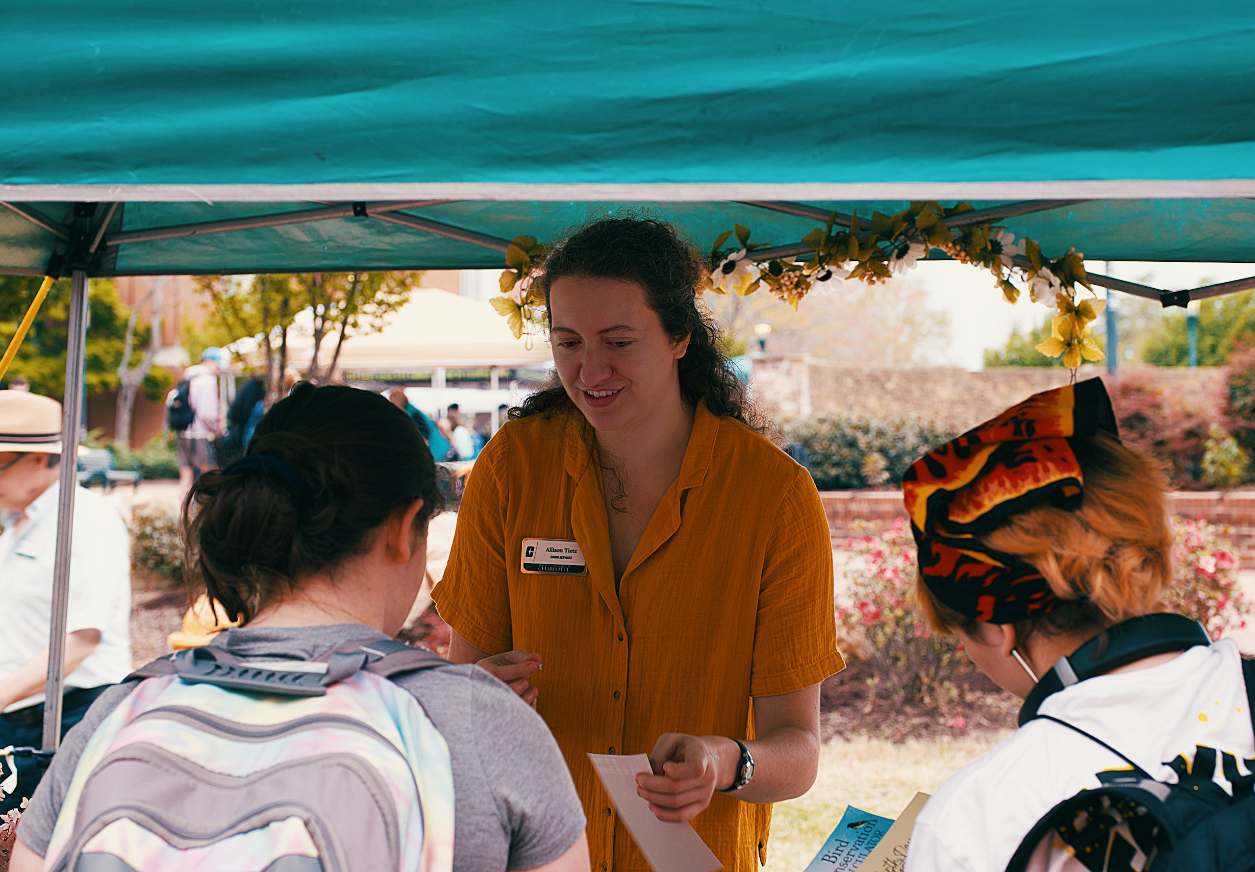 A woman assists people at a public event.