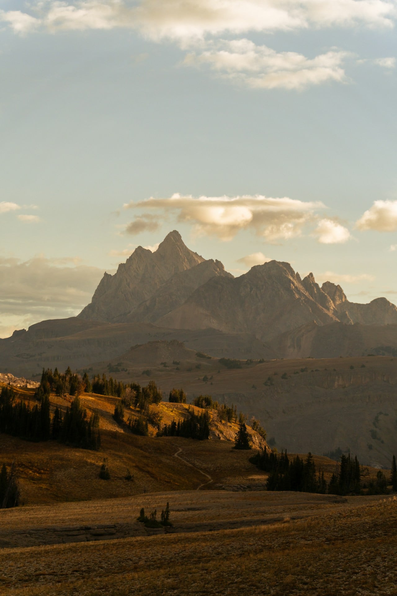 Jagged mountain peaks at sunset with golden hills