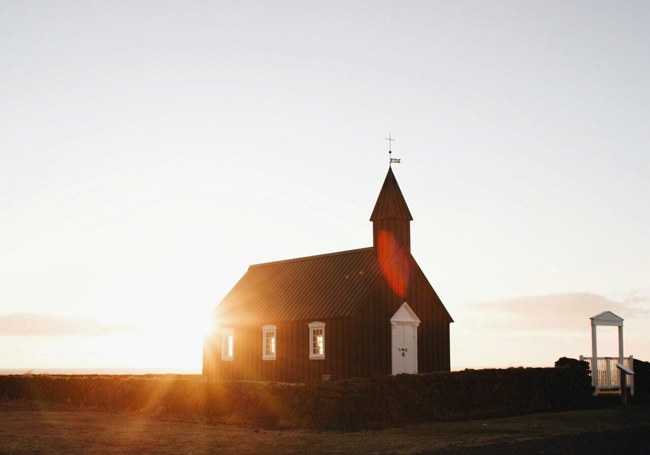brown chapel surrounded green grass