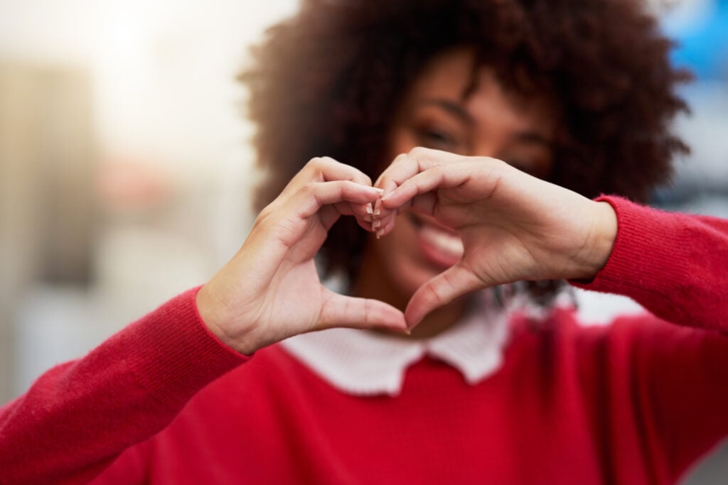Cropped shot of an unrecognizable woman forming a heart shape with her fingers