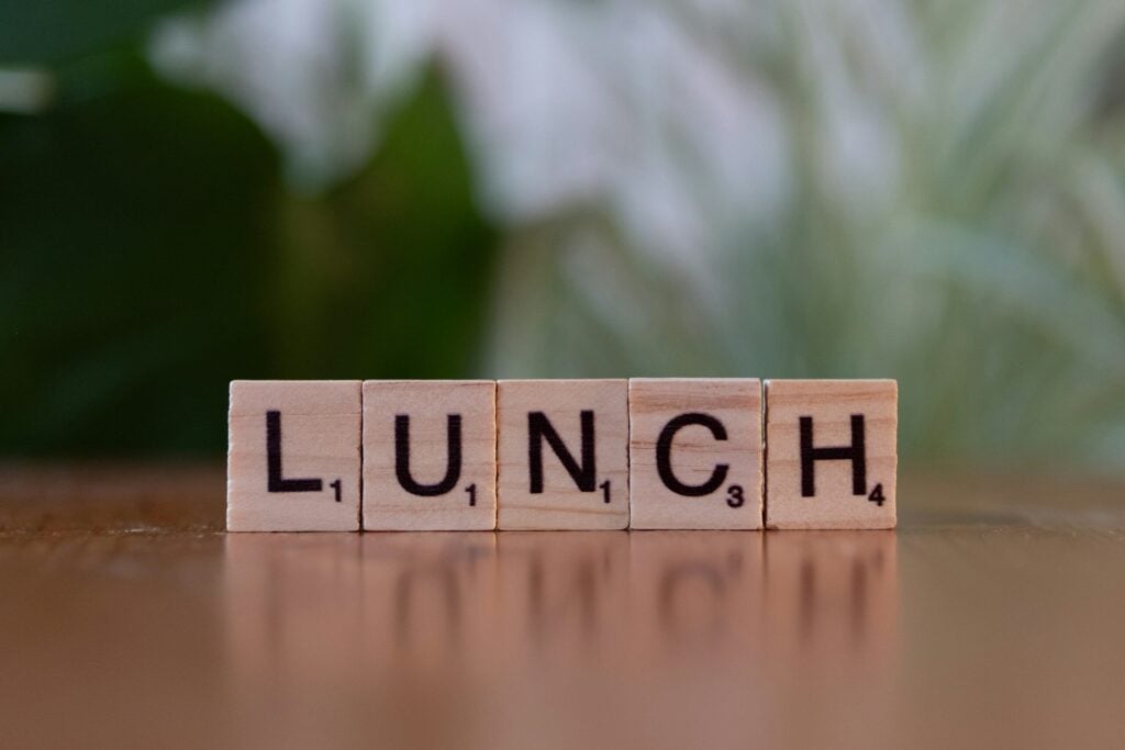 A wooden block spelling lunch on a table
