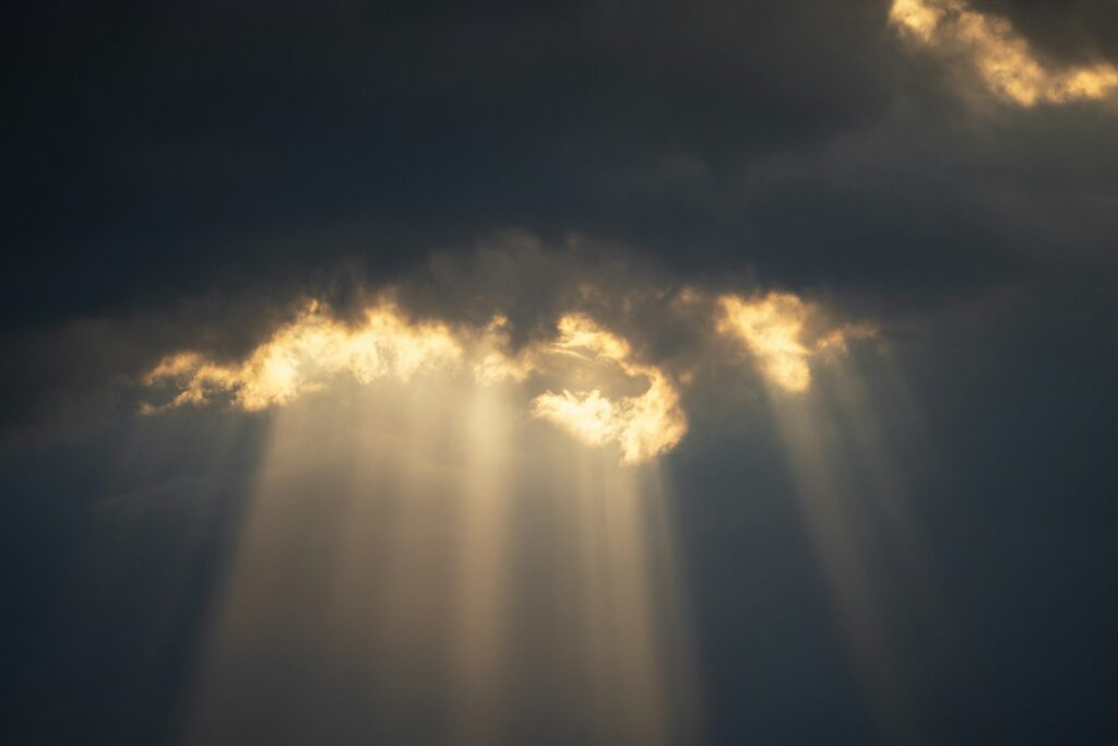Sun rays breaking through dark clouds.