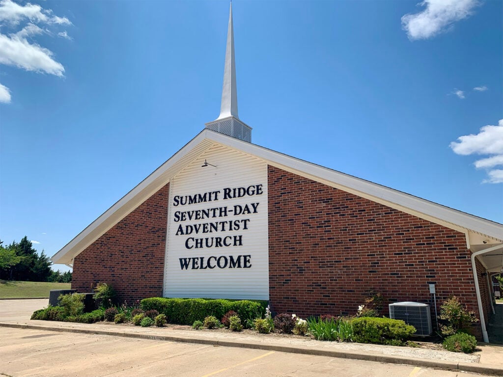 Seventh-day Adventist church with white steeple and welcome sign at Summit Ridge Retirement Village