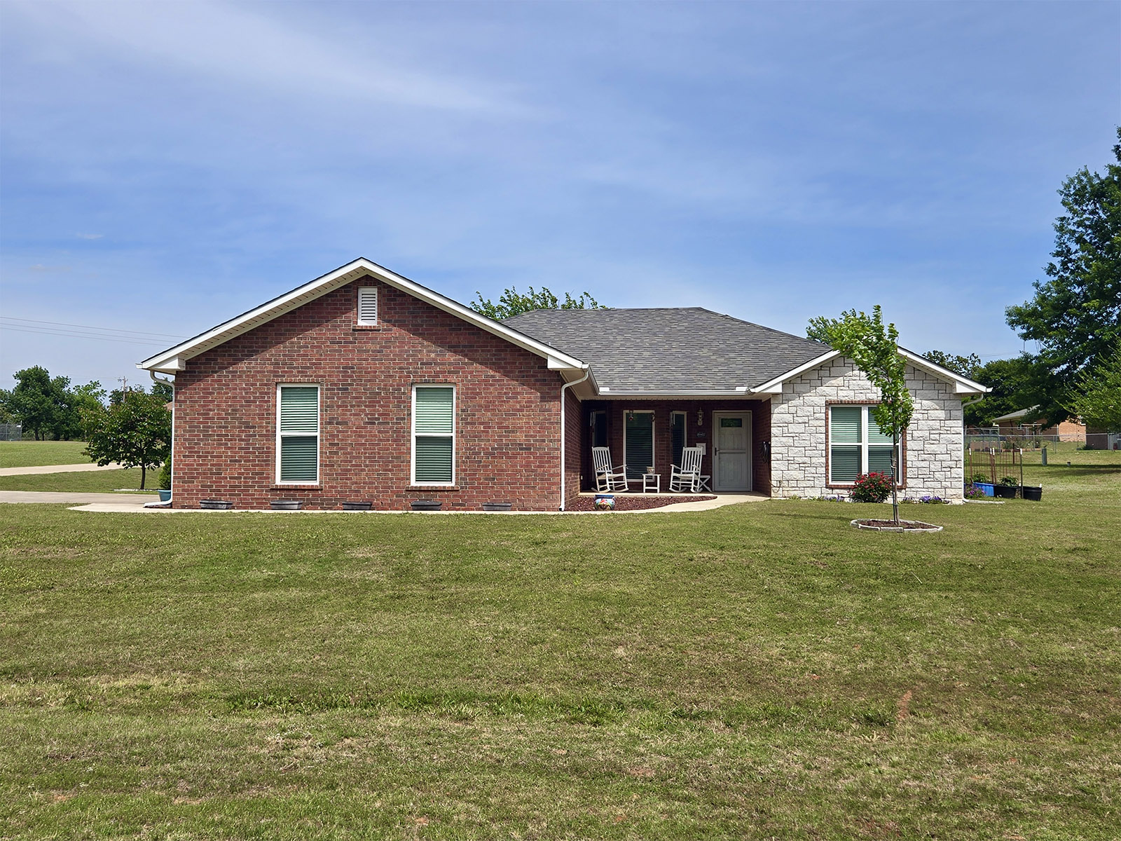 Brick home in Summit Ridge Retirement Village with mixed red and beige brick exterior, green lawn, and a walkway leading to the entrance, representing housing options available in the community.